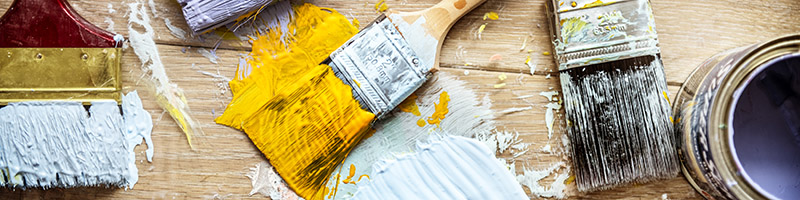 An image of a number of paint brushes with paint on them.